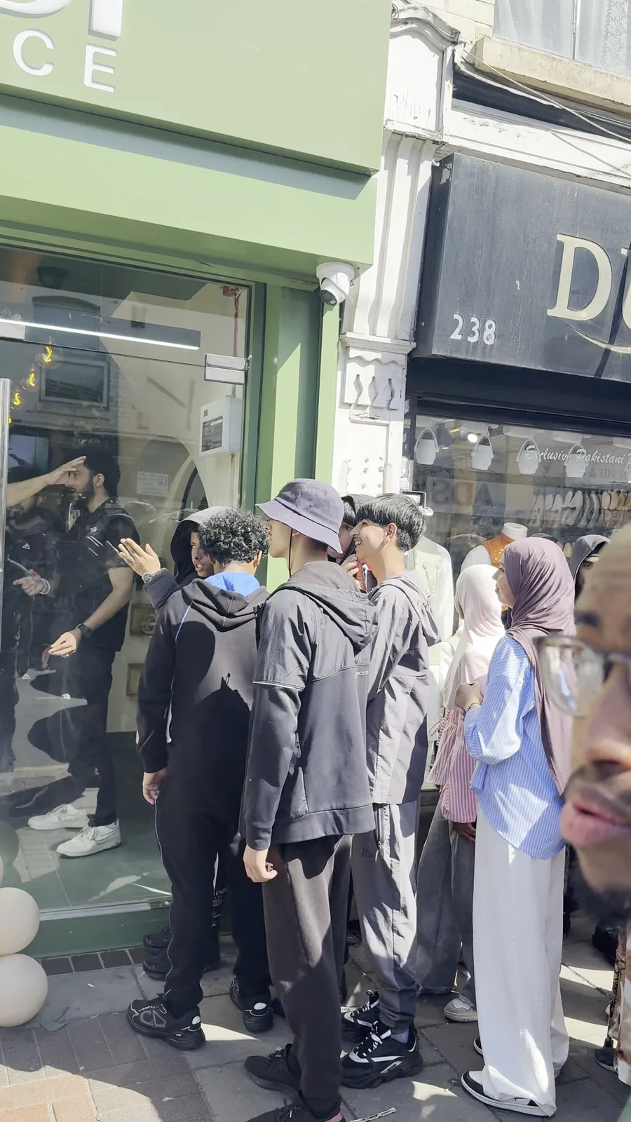 A group of customers waiting together outside Habibi Juice on opening day.