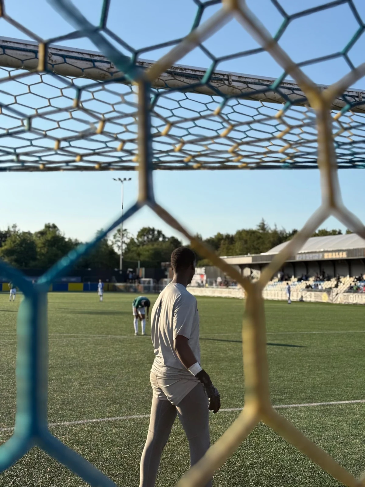 Unity Cup match action photographed through the goal net.