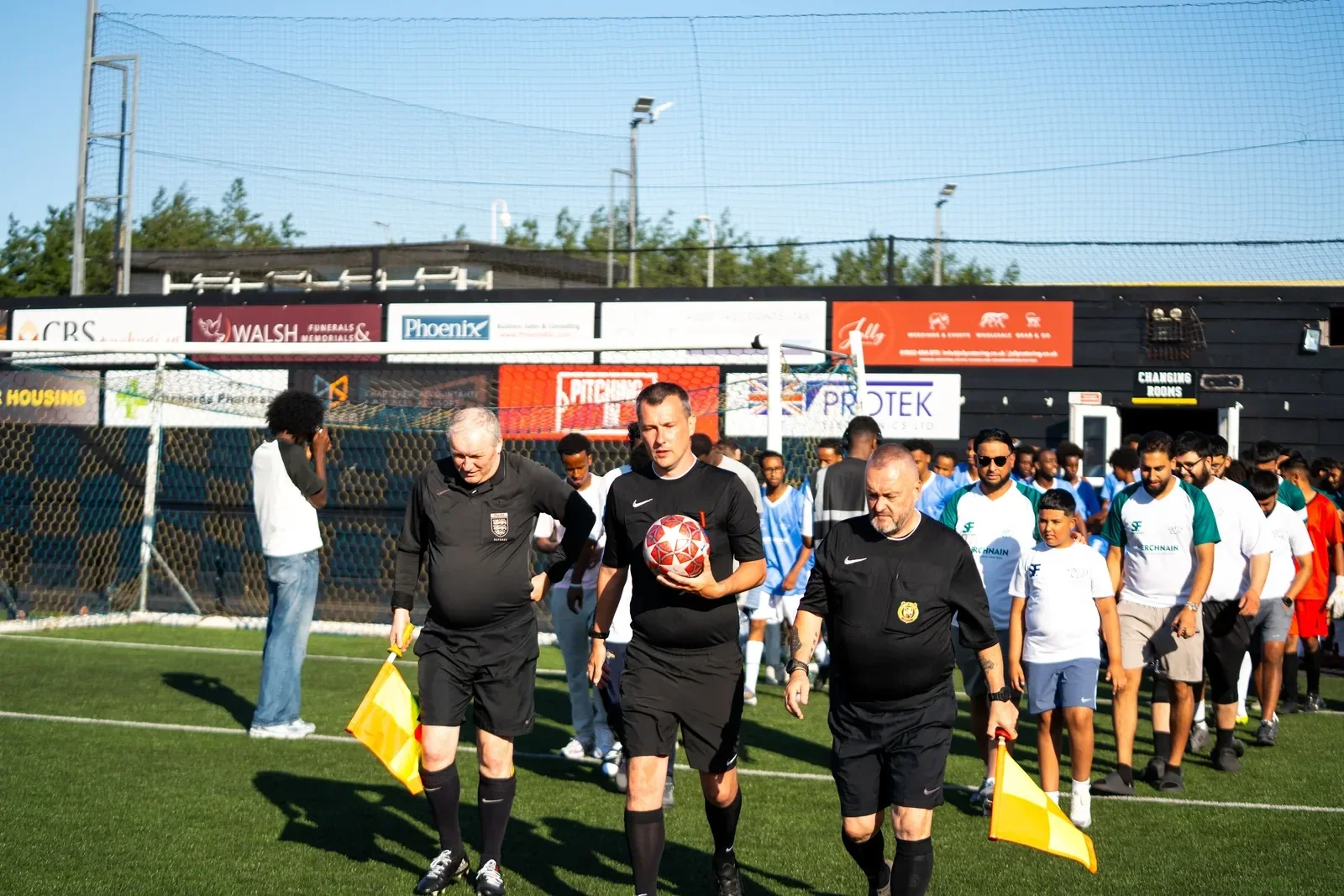 Both Unity Cup teams and officials gathered together on the pitch.